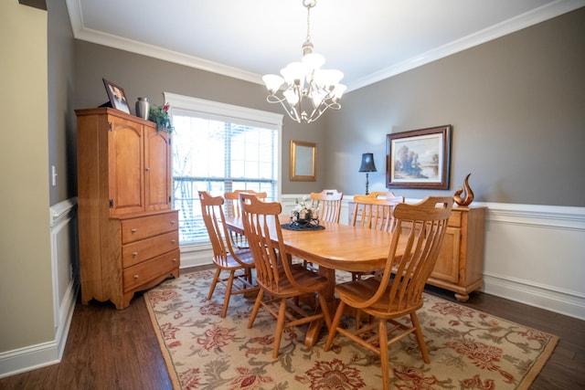 dining room with baseboards, a chandelier, crown molding, and wood finished floors