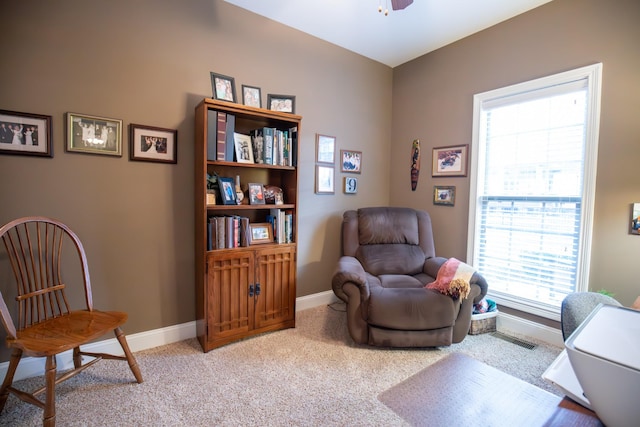 sitting room with baseboards, a ceiling fan, visible vents, and light colored carpet