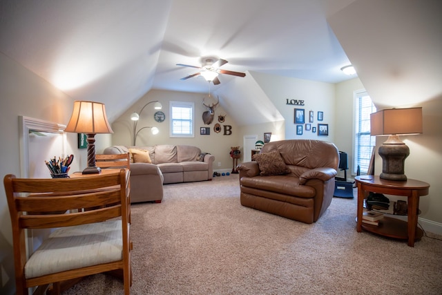 carpeted living area with lofted ceiling, ceiling fan, and baseboards