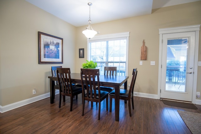 dining space featuring dark wood-style floors and baseboards