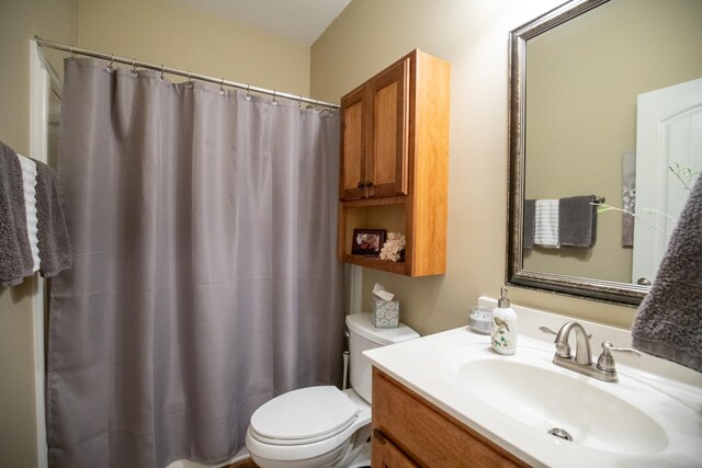 bathroom with a shower with shower curtain, vanity, and toilet