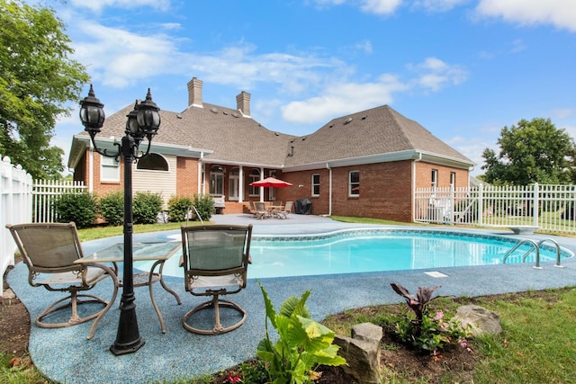 view of swimming pool with a patio area, fence, and a fenced in pool