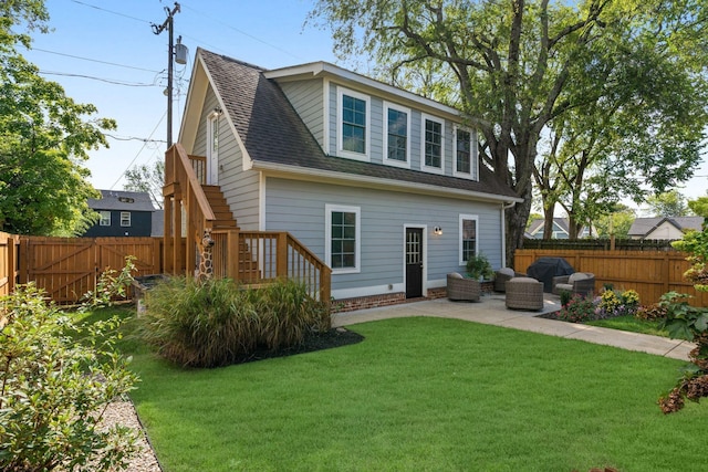 rear view of house with a patio, a fenced backyard, a shingled roof, stairs, and a lawn