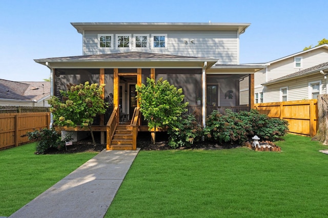 view of front of property with a front yard, fence private yard, and a sunroom