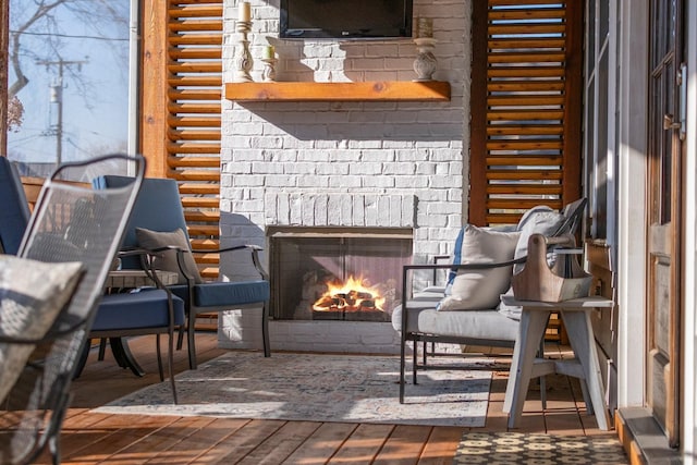 living area with a brick fireplace and wood finished floors