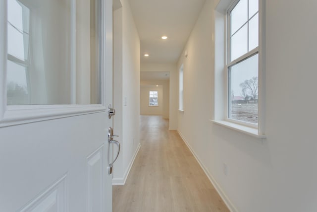 corridor with baseboards, recessed lighting, and light wood-style floors