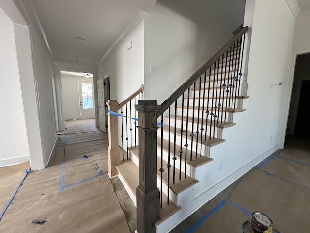 staircase with crown molding and baseboards