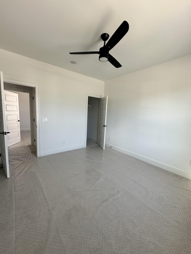 unfurnished bedroom with a ceiling fan, light carpet, and baseboards