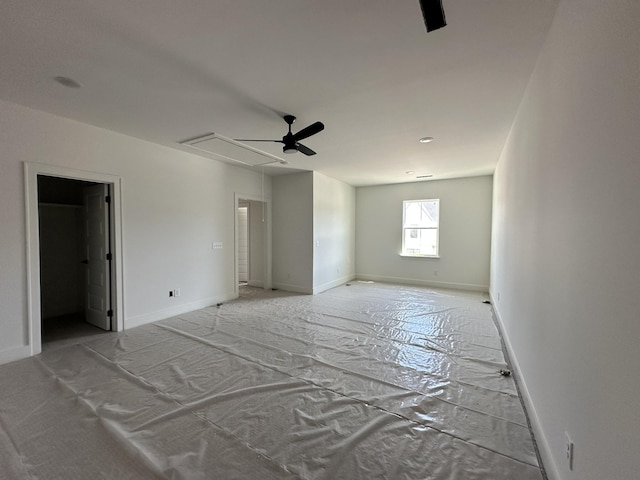 unfurnished room with attic access and baseboards