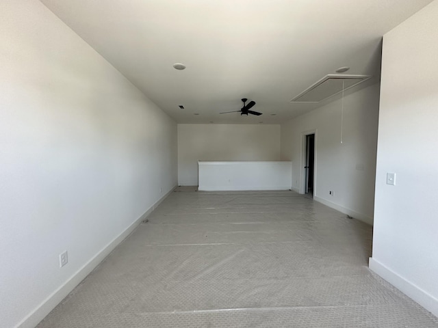 empty room with attic access and baseboards