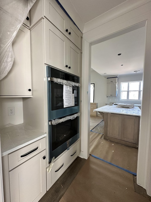 kitchen featuring light stone counters and double wall oven