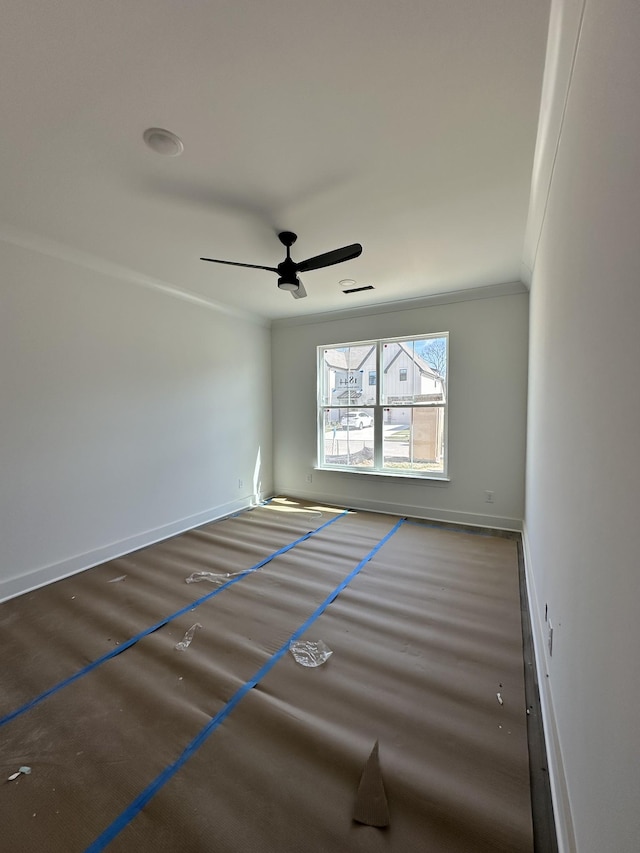 empty room with baseboards, ornamental molding, ceiling fan, and wood finished floors