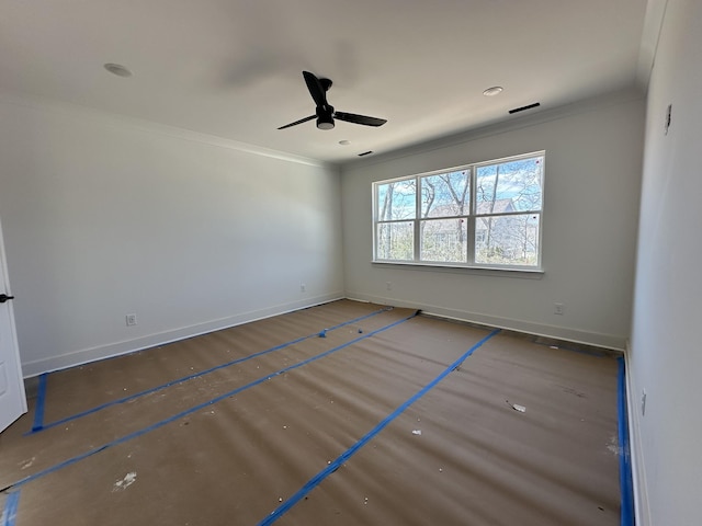 spare room with ornamental molding, visible vents, ceiling fan, and baseboards