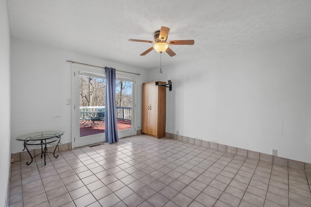 unfurnished room featuring ceiling fan, a textured ceiling, and light tile patterned floors