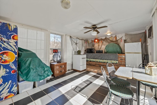 sunroom / solarium with a ceiling fan and washer / dryer