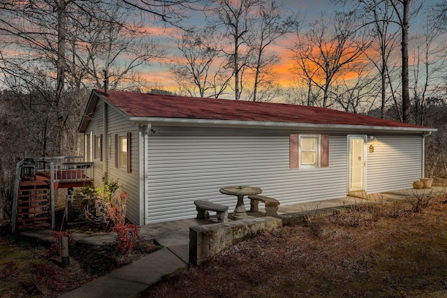 property exterior at dusk featuring a wooden deck