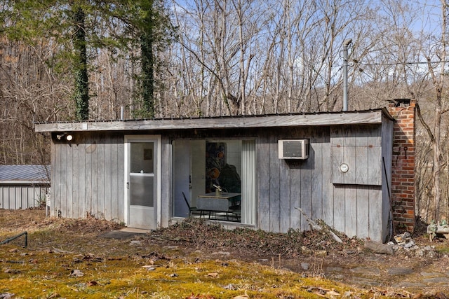 view of outdoor structure featuring an AC wall unit and an outdoor structure