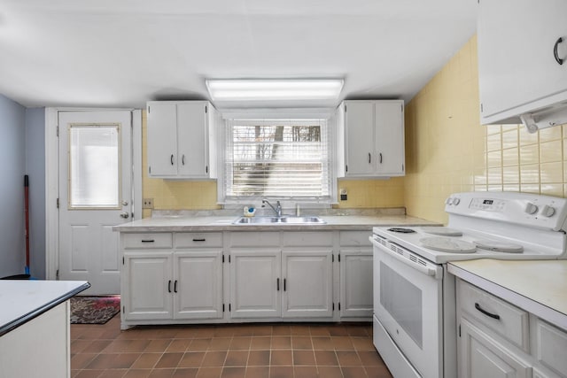 kitchen featuring white cabinets, white range with electric stovetop, backsplash, and a sink