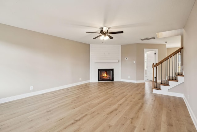 unfurnished living room with visible vents, baseboards, light wood-style flooring, stairway, and a fireplace