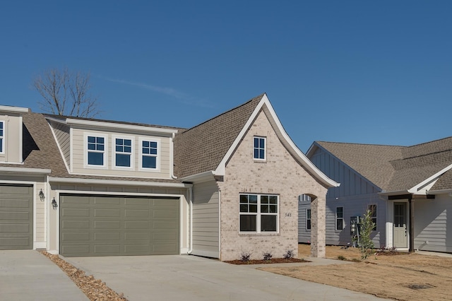 view of front of house with a garage, concrete driveway, a shingled roof, and board and batten siding