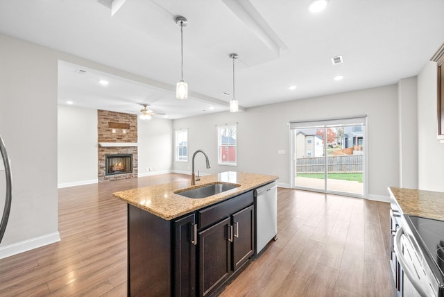 kitchen with visible vents, hanging light fixtures, stainless steel appliances, light wood-type flooring, and a sink