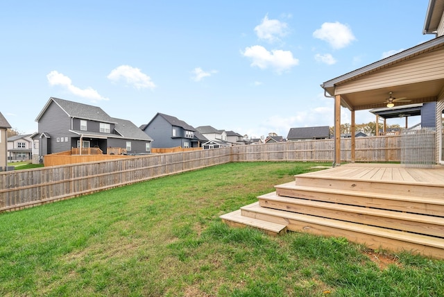 view of yard featuring a residential view, a fenced backyard, ceiling fan, and a wooden deck