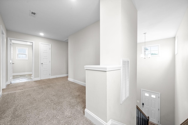 corridor with carpet, visible vents, and baseboards