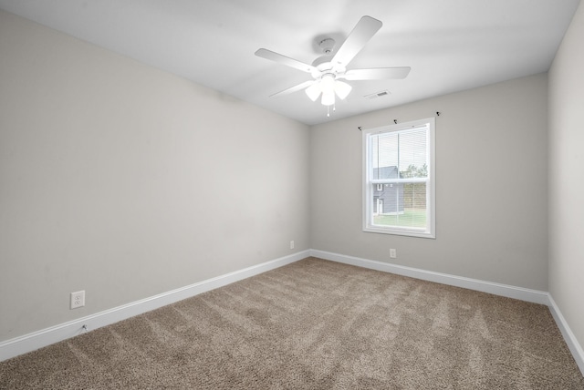 unfurnished room featuring carpet floors, visible vents, baseboards, and a ceiling fan