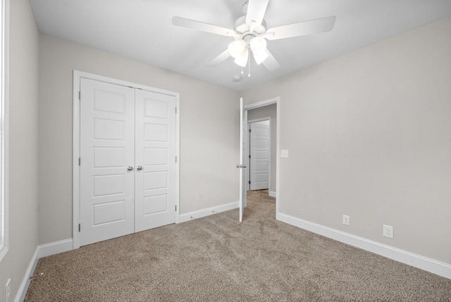 unfurnished bedroom featuring a ceiling fan, carpet, a closet, and baseboards