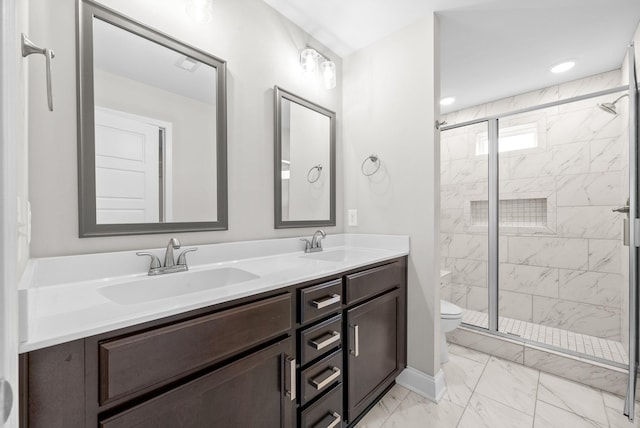 bathroom featuring marble finish floor, a sink, toilet, and a shower stall