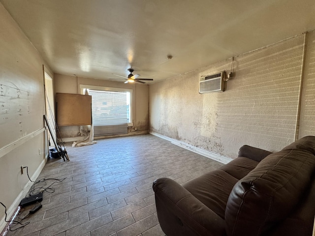 living room featuring a ceiling fan, baseboards, and an AC wall unit