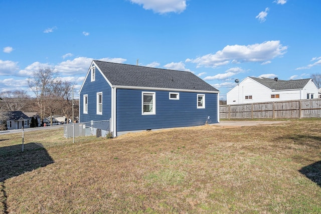 back of property featuring a yard, a shingled roof, crawl space, and a fenced backyard