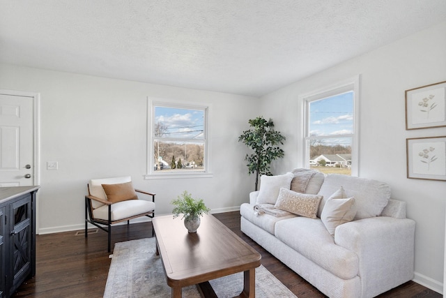 living room with dark wood-style floors, a textured ceiling, and a wealth of natural light