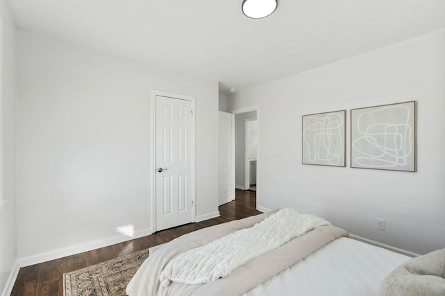 bedroom featuring dark wood-style floors and baseboards