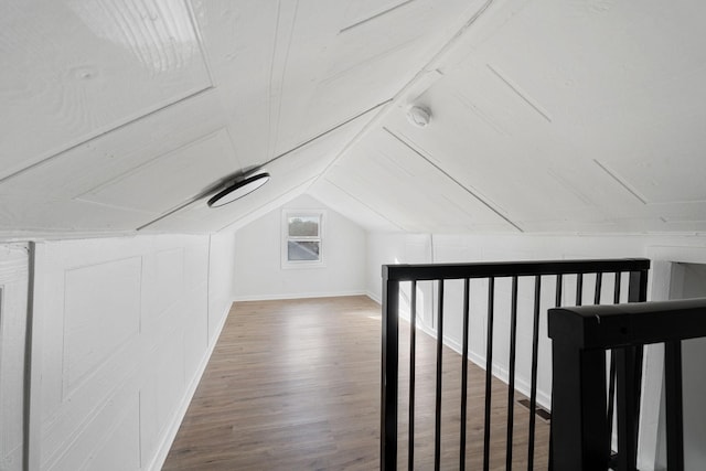 additional living space featuring vaulted ceiling and wood finished floors