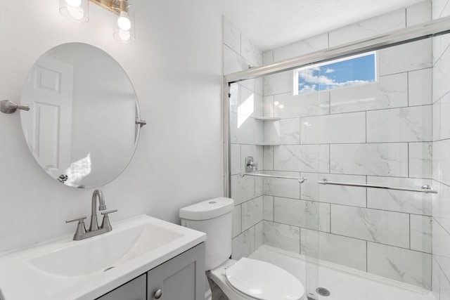 bathroom featuring a textured ceiling, a stall shower, vanity, and toilet