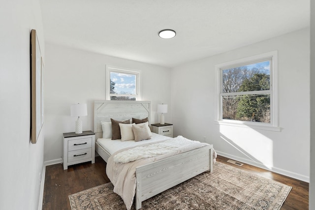 bedroom featuring dark wood-type flooring, visible vents, and baseboards