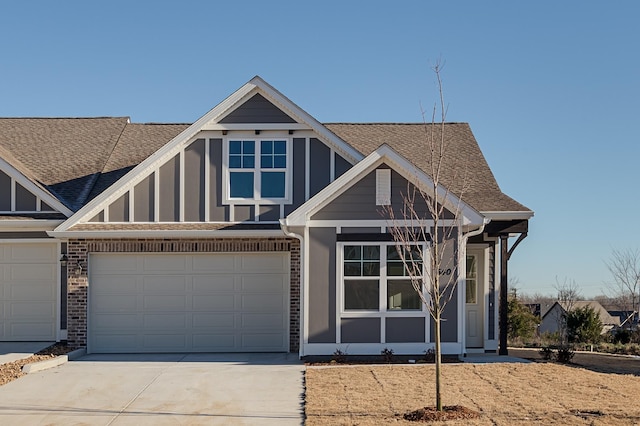 view of front of property with driveway, brick siding, and a shingled roof