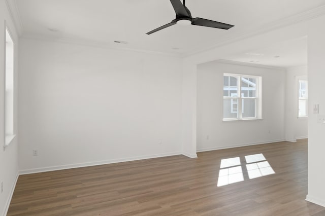 unfurnished room with ceiling fan, baseboards, wood finished floors, and crown molding