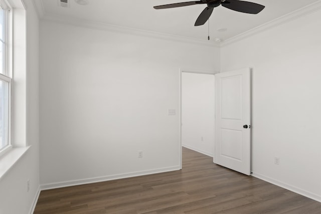 unfurnished room with baseboards, wood finished floors, a wealth of natural light, and crown molding