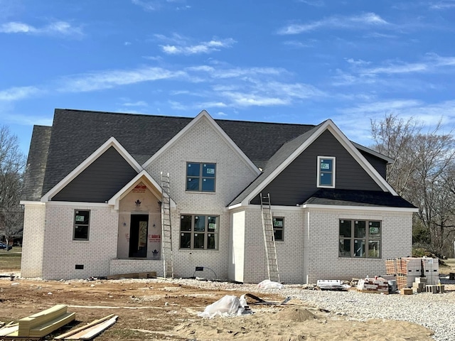 view of front of house with a shingled roof, crawl space, and brick siding