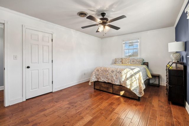 bedroom with wood-type flooring, visible vents, baseboards, and ornamental molding