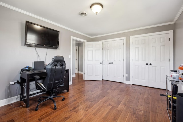 office space featuring visible vents, crown molding, baseboards, and wood finished floors