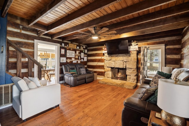 living room featuring a stone fireplace, wood walls, wood ceiling, visible vents, and wood-type flooring