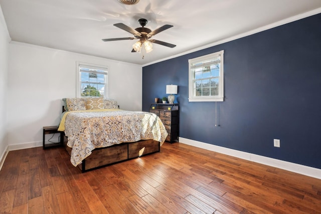 bedroom featuring wood-type flooring, multiple windows, and crown molding