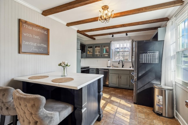 kitchen with stone tile floors, gray cabinetry, a sink, light countertops, and stainless steel dishwasher