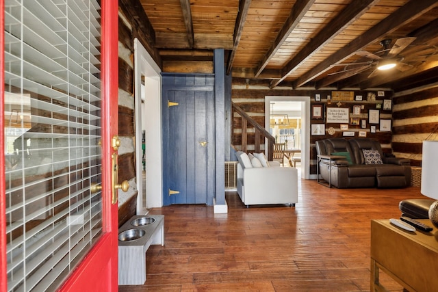 interior space featuring beam ceiling, wood walls, and hardwood / wood-style floors