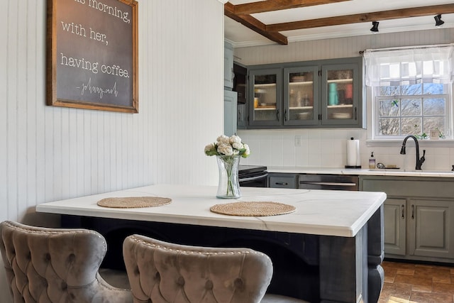 interior space with dishwasher, glass insert cabinets, a sink, and gray cabinetry