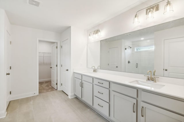 full bath featuring double vanity, a stall shower, visible vents, and a sink