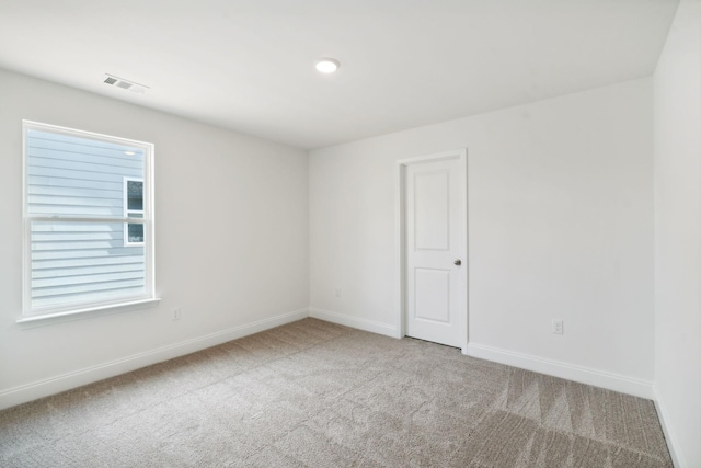 spare room featuring baseboards, visible vents, and carpet flooring